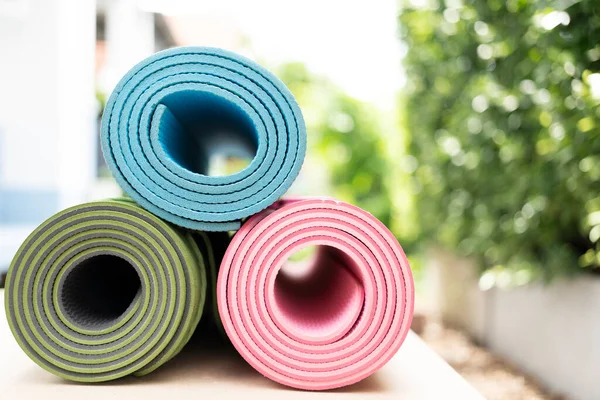 close up of colorful yoga mat on the table, sport and healthy concept