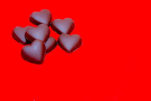 Chocolate hearts on red — Stock Photo, Image