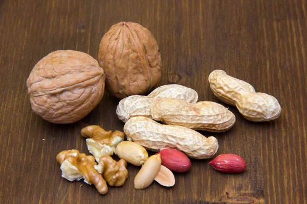 Cacahuetes y nueces en madera — Foto de Stock