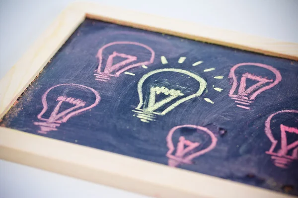 Funny lightbulb on blackboard, concept of uniqueness — Stock Photo, Image