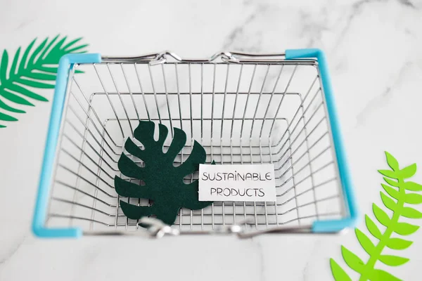 環境意識と消費者行動の概念図 熱帯緑の紙の葉を持つショッピングバスケットの持続可能な製品テキスト — ストック写真