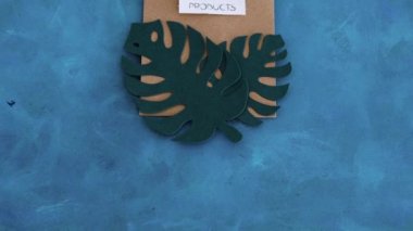 Çevresel farkındalık ve tüketici davranışı kavramsal imaj, üzerinde tropik yeşil kağıt yapraklar olan alışveriş torbaları üzerine sürdürülebilir ürün metni