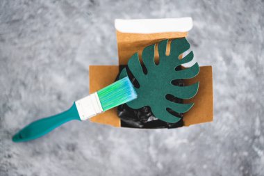 yeşil yıkama ve sürdürülebilir kavramsal görüntü gibi davranan şirketler, üzerinde yeşil fırça resmi olan kağıt yaprak ürün ambalajı