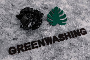 yeşil çamaşır ve sürdürülebilir kavramsal görüntü gibi davranan şirketler, altında yazı olan atık parçalarının yanında kağıt yaprak