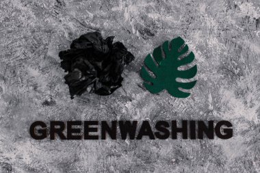 yeşil çamaşır ve sürdürülebilir kavramsal görüntü gibi davranan şirketler, altında yazı olan atık parçalarının yanında kağıt yaprak