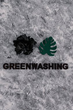 yeşil çamaşır ve sürdürülebilir kavramsal görüntü gibi davranan şirketler, altında yazı olan atık parçalarının yanında kağıt yaprak