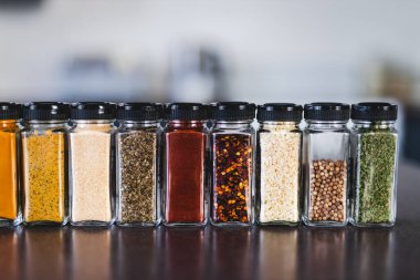 Baharat tohumları ve baharatlar düzenli kiler rafındaki baharat kavanozları, basit vejetaryen malzemeleri ve yemeklerinizin lezzeti.