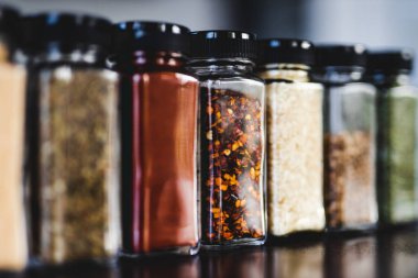Baharat tohumları ve baharatlar düzenli kiler rafındaki baharat kavanozları, basit vejetaryen malzemeleri ve yemeklerinizin lezzeti.
