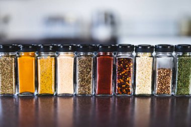 Baharat tohumları ve baharatlar düzenli kiler rafındaki baharat kavanozları, basit vejetaryen malzemeleri ve yemeklerinizin lezzeti.