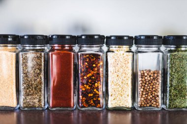 Baharat tohumları ve baharatlar düzenli kiler rafındaki baharat kavanozları, basit vejetaryen malzemeleri ve yemeklerinizin lezzeti.