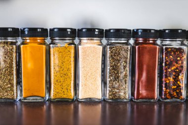 Baharat tohumları ve baharatlar düzenli kiler rafındaki baharat kavanozları, basit vejetaryen malzemeleri ve yemeklerinizin lezzeti.