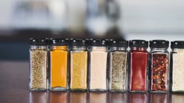 Baharat tohumları ve baharatlar mutfak tezgahındaki aynı baharat kavanozlarında, basit vejetaryen malzemeleri ve yemeklerinizi tatlandırma konsepti.