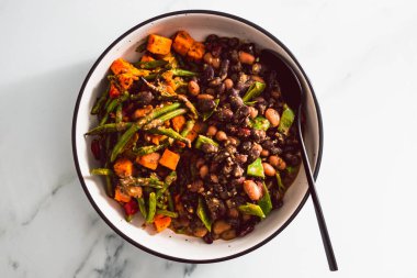 Vegan Meksika 'dan esinlenilmiş fasulye fasulyesi taze fasulye ve tatlı patates, sağlıklı bitki temelli yemek tarifleri.