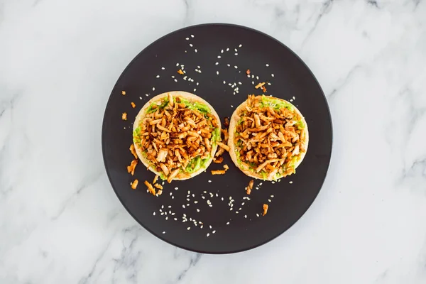 vegan shredded marinated teriyaki tofu with avocado guacamole on top of English muffins, healthy plant-based food recipes