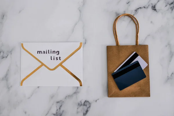 電子メールマーケティングと顧客に加入者を変換 ショッピングバッグの上にメーリングリストラベルと支払いカードと電子メール封筒 — ストック写真