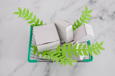 sürdürülebilirlik ve zulüm içermeyen ürün konsepti, boş ürün paketleriyle alışveriş septi ve yeşil yapraklar