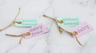 Bitki temelli ve hayvan bazlı etiketler mermer tablonun üzerinde, sağlıklı beslenme kavramı ve etik seçimler