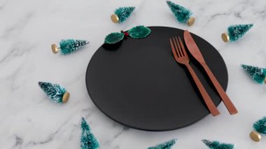 Altın çatal bıçak takımı siyah yemek tabağının üstünde. Her yerde Chrismtas süslemeleri mermer masa, festival sezonu ve tatil yemekleri konsepti var.