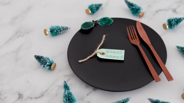 大理石のテーブルの上にクリスマスの装飾が施された黒いダイニングプレートの上に植物ベースのラベル 健康的な栄養とビーガンクリスマスフードコンセプト — ストック動画