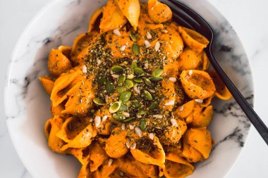 Ev yapımı kremalı tofu ve dolma biber soslu vejetaryen kabuklu makarna, sağlıklı bitki temelli yemek tarifleri.