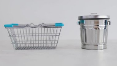 Tüketime karşı sürdürülebilir ürünler ve kasıtlı alışveriş kavramsal imaj, iyi satın alınması için alışveriş sepeti fazla malların üretilmesi veya etiketlerle satın alınması için geri dönüşüm kutusunun yanında