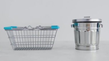 Tüketime karşı sürdürülebilir ürünler ve kasıtlı alışveriş kavramsal imaj, iyi satın alınabilecek gereçler için geri dönüşüm kutusunun yanında alışveriş sepeti