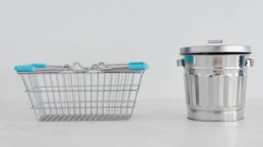 Tüketime karşı sürdürülebilir ürünler ve kasıtlı alışveriş kavramsal imaj, iyi satın alınabilecek gereçler için geri dönüşüm kutusunun yanında alışveriş sepeti