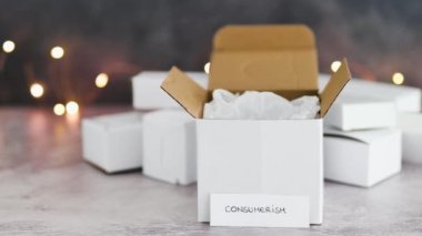 Tüketim kavramsal görüntüsü, arka planda parlak peri ışıkları ve metin ile satın alınan mallar için teslimat paketleri