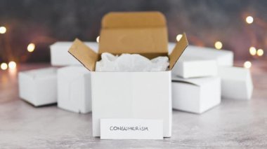 Tüketim kavramsal görüntüsü, arka planda parlak peri ışıkları ve metin ile satın alınan mallar için teslimat paketleri