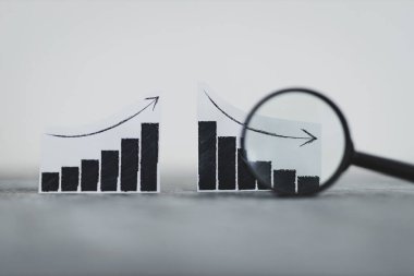 finansal piyasalar veya para ve yatırım konsepti, yukarı ve aşağı eğilimleri gösteren grafikler ve büyüteç analizi bunlardan biri sığ alan derinliğinde çekilmiştir