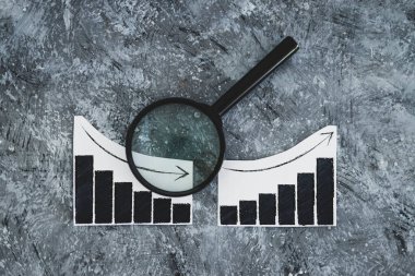 finansal piyasalar veya para ve yatırım konsepti, yukarı ve aşağı eğilimleri gösteren grafikler ve büyüteç analizi bunlardan biri sığ alan derinliğinde çekilmiştir