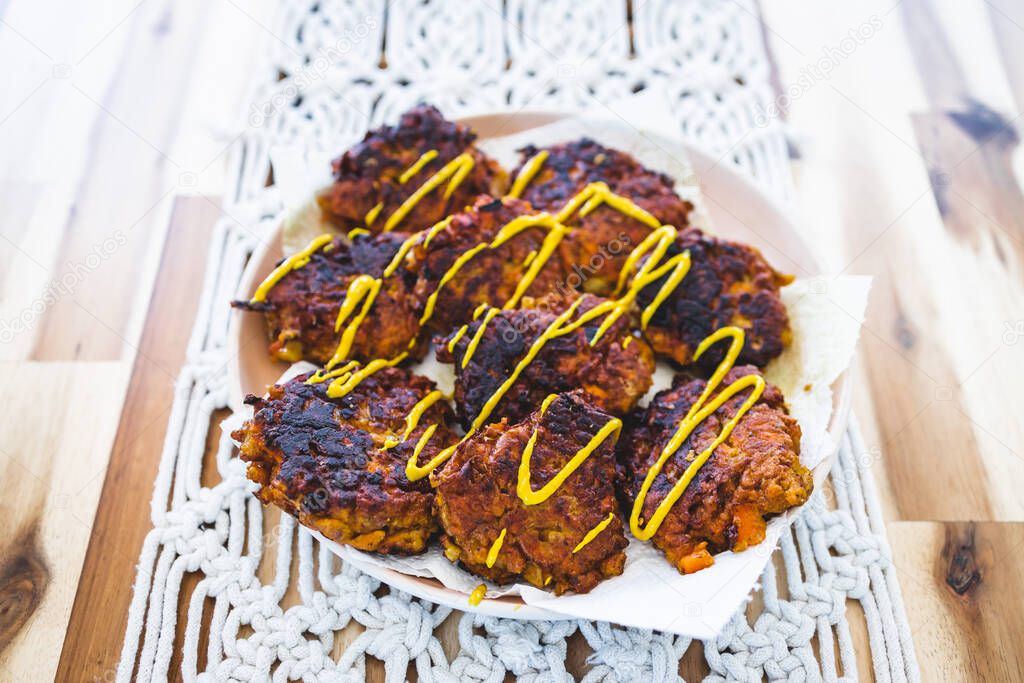 vegan curried carrot and onion fritters topped with mustard, healthy plant-based food recipes