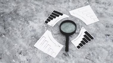 finansal piyasalar veya para ve yatırımlar kavramsal imaj, grafikler yukarı ve aşağı eğilimleri gösteren büyüteç