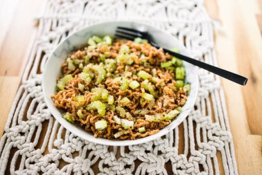 Zencefilli ve soya soslu vejetaryen hazır şehriye. Üstünde kertenkele tohumu ve kırmızı biber taneleri, sağlıklı bitki temelli yemek tarifleri.