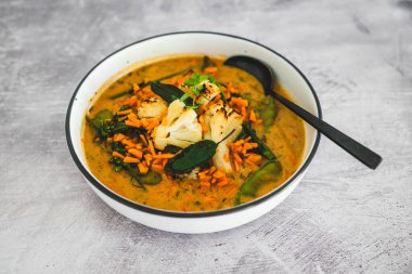 Havuç, kertenkele ve maydanozlu vejetaryen sarı karnabahar körisi, sağlıklı bitki temelli yemek tarifleri.