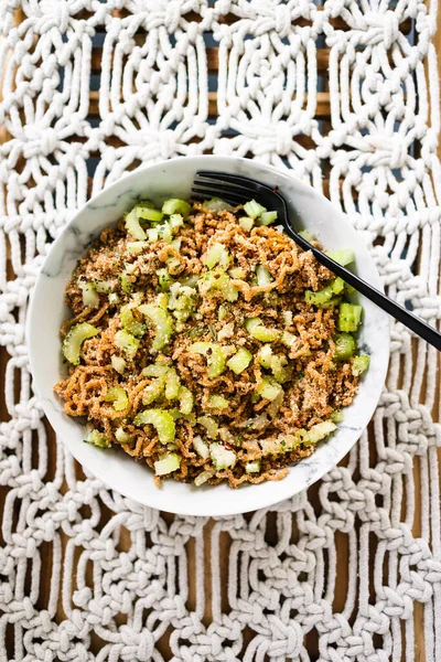 Zencefilli ve soya soslu vejetaryen hazır şehriye. Üstünde kertenkele tohumu ve kırmızı biber taneleri, sağlıklı bitki temelli yemek tarifleri.