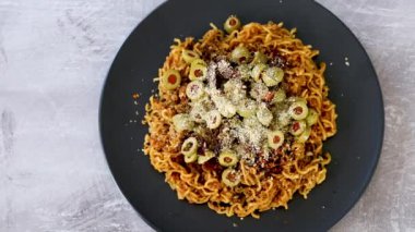 Üzeri zeytinli zencefilli erişte kurutulmuş domates ve parmesanlı kaju soslu sağlıklı bitkisel gıda kavramı.