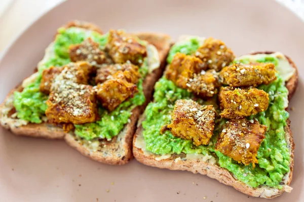 Veganer Avocado Toast Garniert Mit Mariniertem Tempeh Und Dukkah Gesunden lizenzfreie Stockbilder