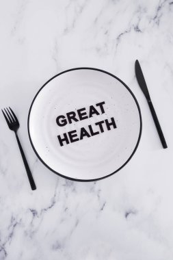 Yemek tabağında çatal ve bıçakla harika bir sağlık metni, beslenme ve sezgisel beslenme kavramı