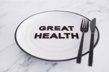 Yemek tabağında çatal ve bıçakla harika bir sağlık metni, beslenme ve sezgisel beslenme kavramı