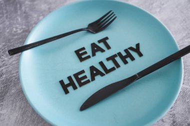 Yemek tabağında çatal ve bıçakla sağlıklı metinler yemek sağlıklı beslenme ve sezgisel yemek kavramı.