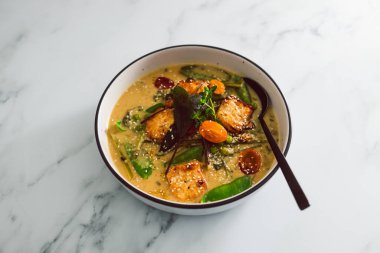 Tavada kızartılmış ipek tofu ve taze toplanmış sebze ve sağlıklı bitki temelli yemek tarifleriyle vegan Thai yeşil köri.