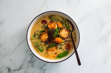 Tavada kızartılmış ipek tofu ve taze toplanmış sebze ve sağlıklı bitki temelli yemek tarifleriyle vegan Thai yeşil köri.