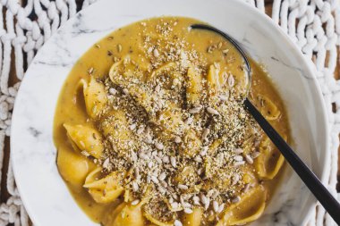 Vejetaryen kremalı kabuklu makarna, kabak sosu ve tohum, sağlıklı bitki temelli yemek tarifleri.