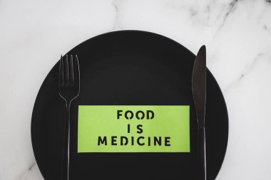 Yemek, çatal ve bıçakla yemek tabağındaki tıbbi metindir. Diyet, sağlıklı beslenme ve sezgisel yemek kavramı.