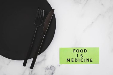 Yemek, çatal ve bıçakla yemek tabağındaki tıbbi metindir. Diyet, sağlıklı beslenme ve sezgisel yemek kavramı.