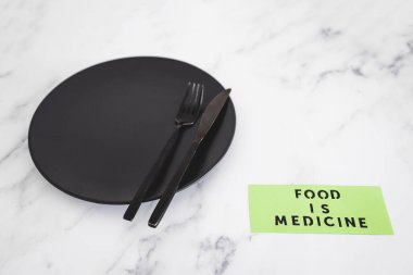 Yemek, çatal ve bıçakla yemek tabağındaki tıbbi metindir. Diyet, sağlıklı beslenme ve sezgisel yemek kavramı.