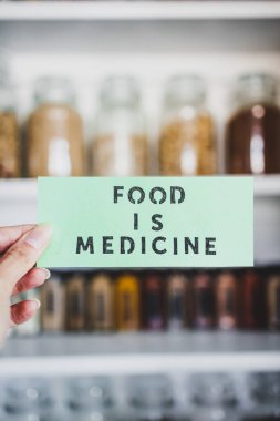 Yiyecek, raflara dizilmiş kavanozlar, sağlıklı beslenme ve sezgisel yemek kavramları olan düzenli organize edilmiş kilerin önündeki tıp metnidir.