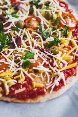 Vejetaryen ev yapımı, kirazlı, zeytinli ve sütsüz peynirli taze otlu pizza, sağlıklı bitkisel yemek tarifleri.