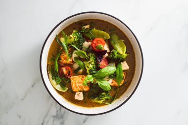 Kızarmış ipek tofu brokoliyle vegan Thai yeşil körisi ve bahçeden taze toplanmış bezelyeler, sağlıklı bitki temelli yemek tarifleri.